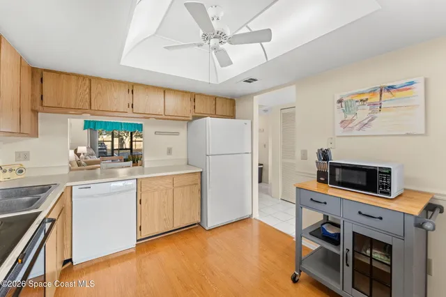 a kitchen with kitchen island a stove a sink and a refrigerator with wooden floor