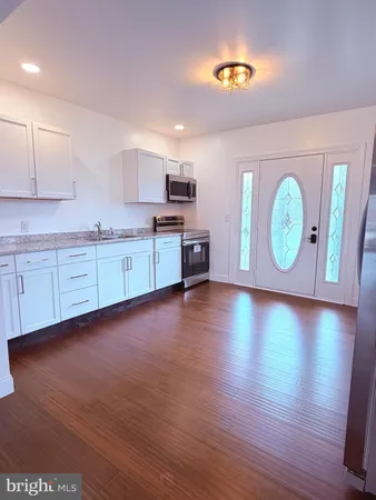 a large kitchen with stainless steel appliances granite countertop a stove a sink and a microwave