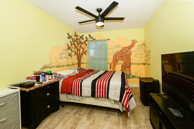 a bedroom with a bed and wooden floor