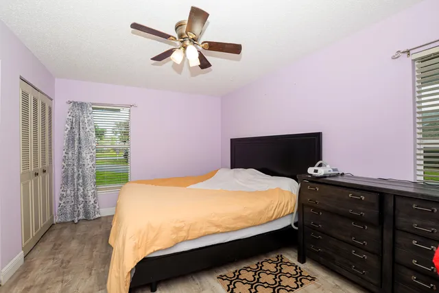 a bedroom with a bed a chandelier and a dresser