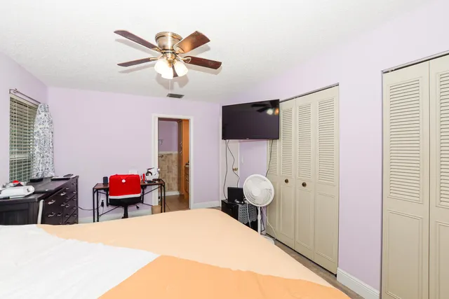 a bedroom with a bed and dresser with mirror