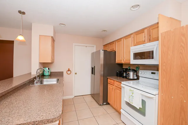 a kitchen with stainless steel appliances kitchen island granite countertop a refrigerator and a stove top oven