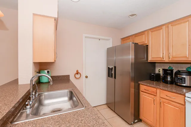 a kitchen with stainless steel appliances granite countertop a sink refrigerator and cabinets