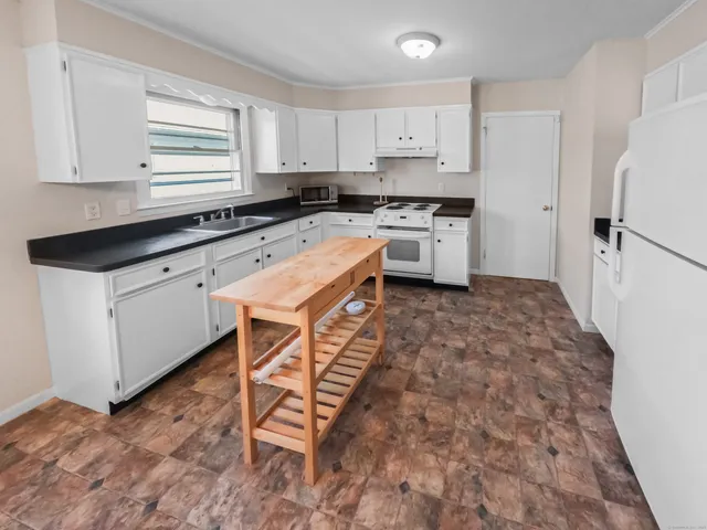 a kitchen with a stove a sink and a window