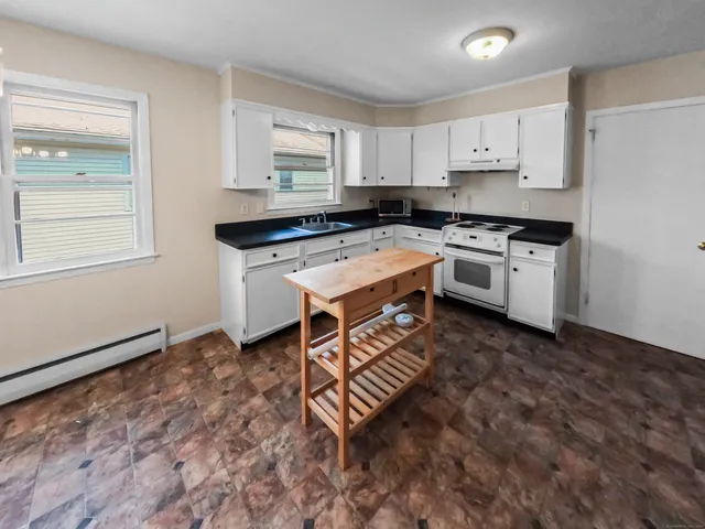 a kitchen with white cabinets and white appliances