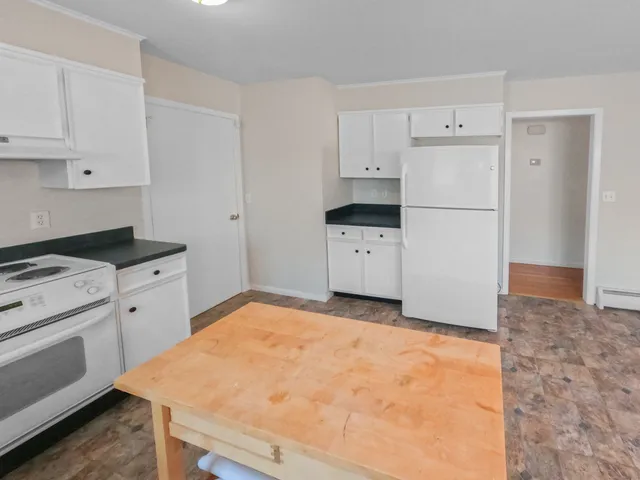 a kitchen with granite countertop a sink and white cabinets