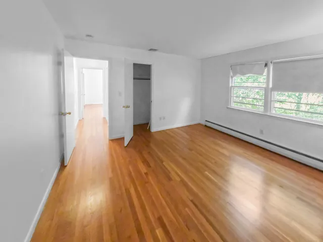 a view of a room with wooden floor and window