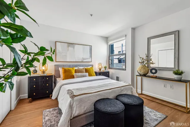 a bedroom with a bed and a potted plant