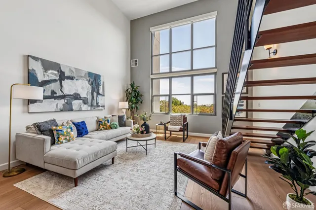 a living room with furniture and a potted plant on a dresser