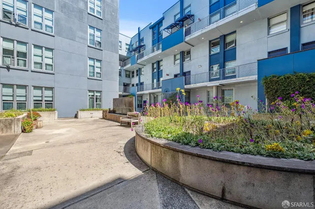 a view of a building with a yard and plants