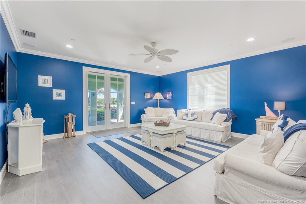 5032 Watersong Way Fort Pierce, FL 34949 - Photo 17 of 55 a living room with furniture two large window and a chandelier