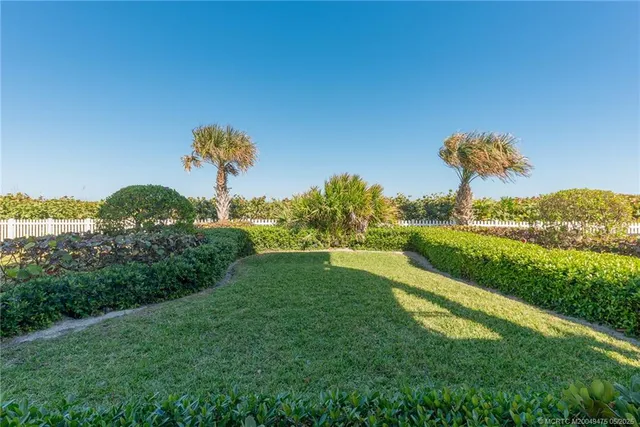 a living room with furniture kitchen view and a chandelier