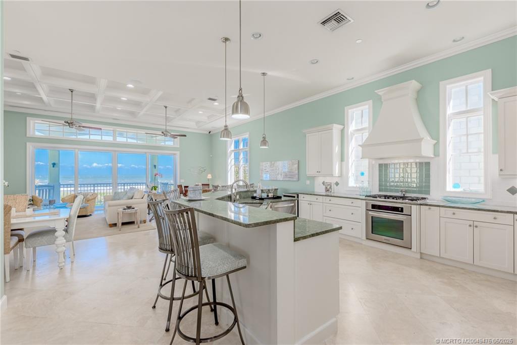 5032 Watersong Way Fort Pierce, FL 34949 - Photo 22 of 55 a large kitchen with a large counter top space a sink stainless steel appliances and cabinets
