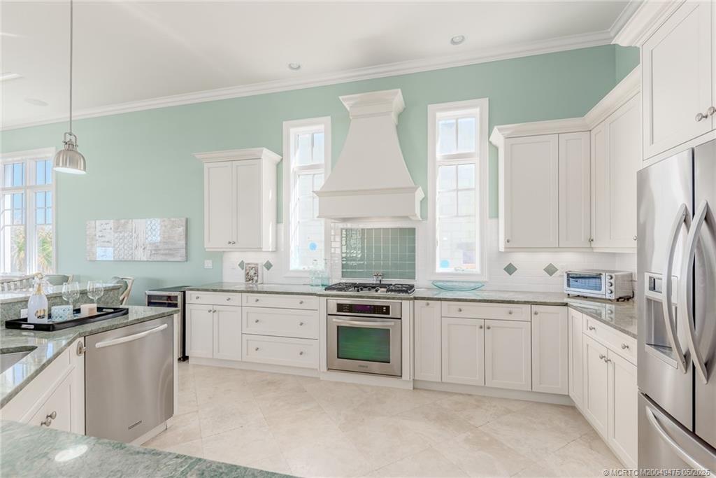 5032 Watersong Way Fort Pierce, FL 34949 - Photo 28 of 55 a kitchen with white cabinets and white appliances