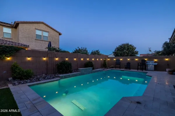 a view of a swimming pool with a yard and plants