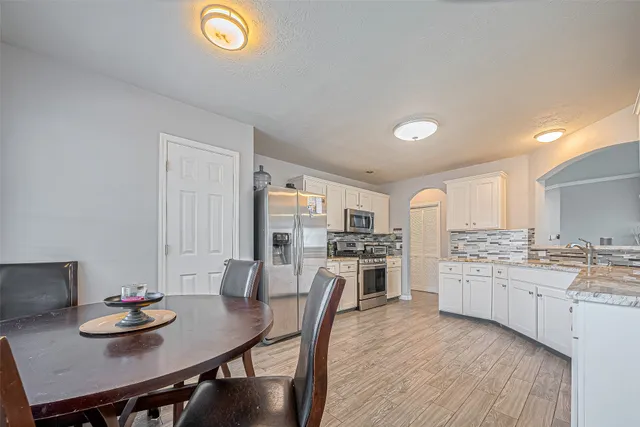 a living room with stainless steel appliances kitchen island granite countertop furniture and a kitchen view