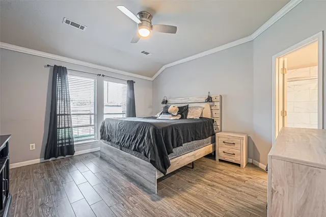 a bedroom with a bed lamp and a large window