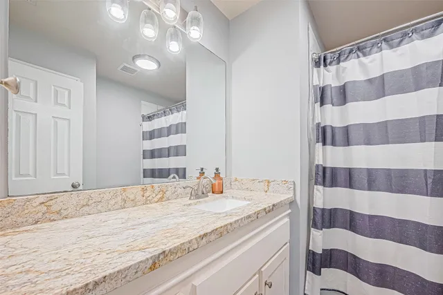 a bathroom with a shower and a sink