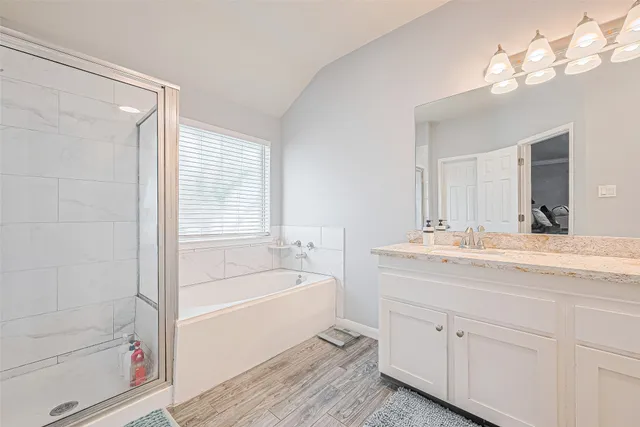 a bathroom with a tub a sink and mirror