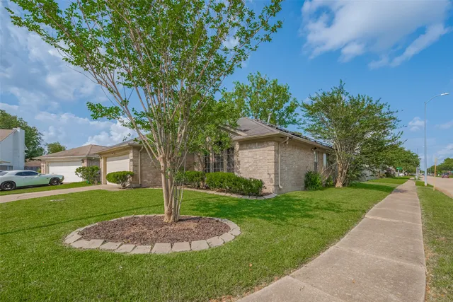 a front view of a house with a yard and trees