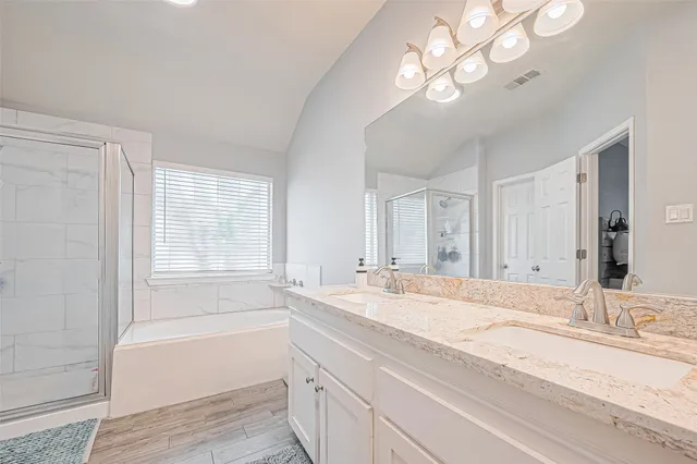 a bathroom with a granite countertop sink a large mirror and a bathtub