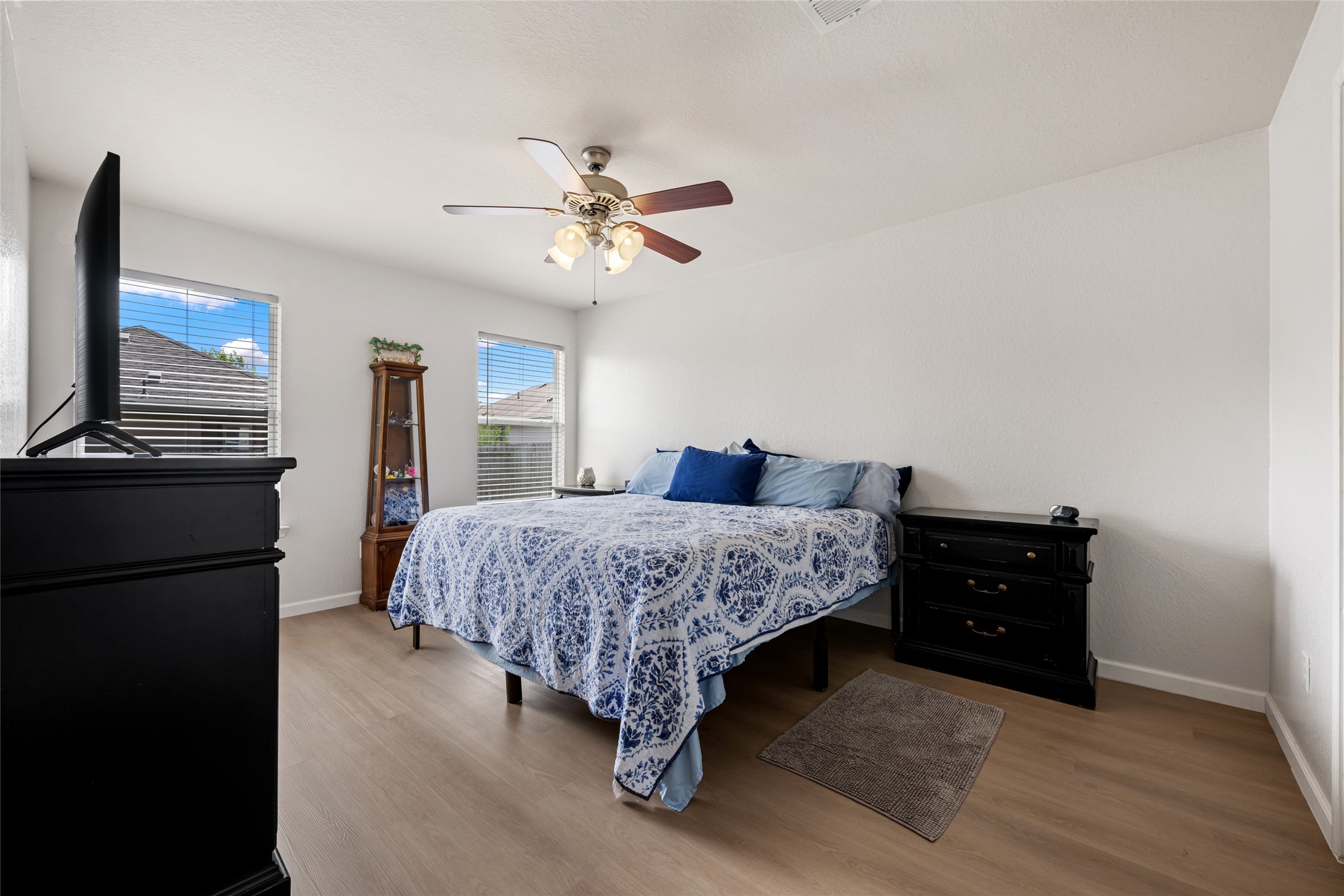 144 Calcite Lane Jarrell, TX 76537 - Photo 19 of 38 Relax in this tranquil bedroom, featuring a warm wooden floor and abundant natural illumination from multiple windows.