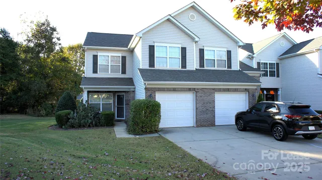 a view of a house with a yard and a car parked in front of house