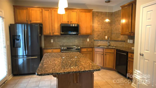 a kitchen with granite countertop a stove and a refrigerator