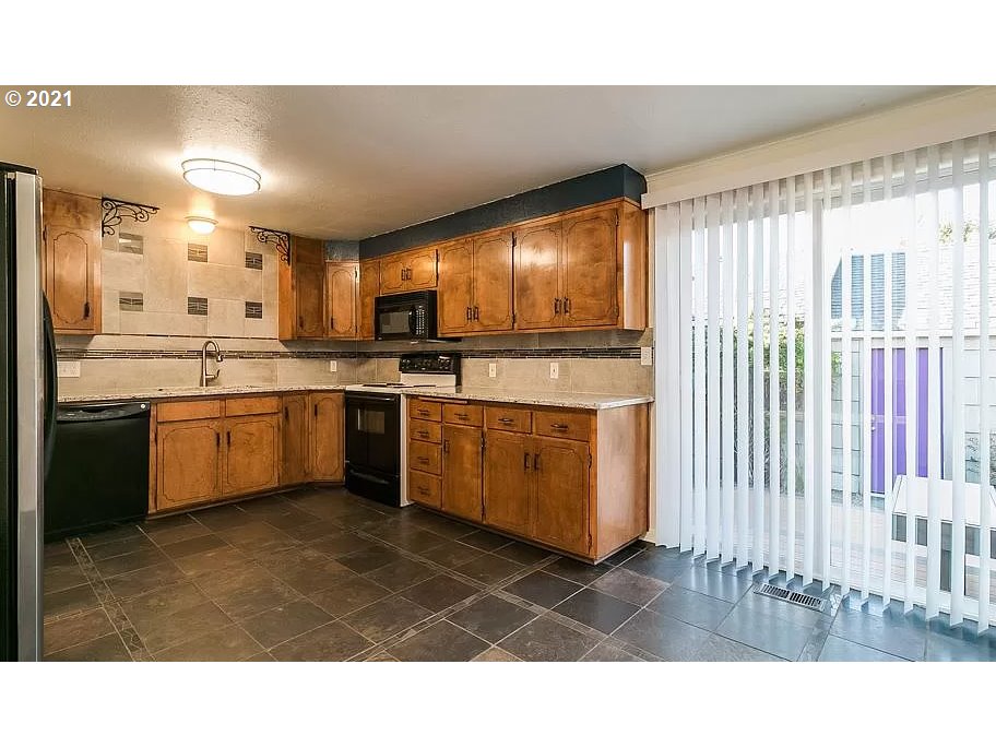 4954 E Street Springfield, OR 97478 - Photo 8 of 23 a kitchen with stainless steel appliances kitchen island granite countertop a stove a sink and a refrigerator