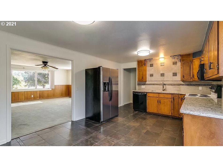 4954 E Street Springfield, OR 97478 - Photo 9 of 23 a kitchen with stainless steel appliances kitchen island granite countertop a refrigerator and a sink