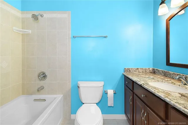 a bathroom with a granite countertop toilet a sink and a bathtub