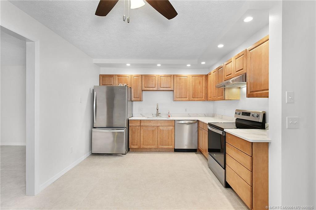 50 Southwest Blackburn Terrace, Unit 8 Stuart, FL 34997 - Photo 22 of 42 a kitchen with a sink a counter top space stainless steel appliances and cabinets