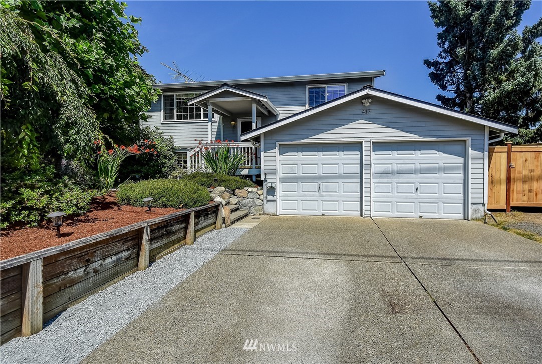 417 212th Street Southwest Bothell, WA 98021 - Photo 1 of 28 a front view of a house with a yard and garage