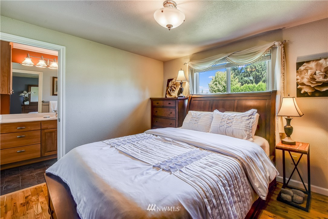 417 212th Street Southwest Bothell, WA 98021 - Photo 12 of 28 a bedroom with a large bed and a dresser