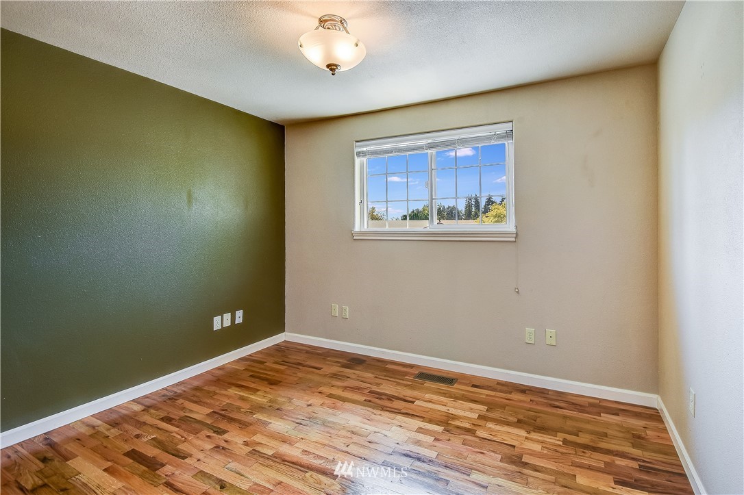 417 212th Street Southwest Bothell, WA 98021 - Photo 14 of 28 a view of an empty room with wooden floor and a window