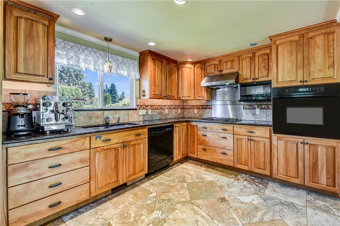 417 212th Street Southwest Bothell, WA 98021 - Photo 9 of 28 a kitchen with granite countertop a stove sink and cabinets