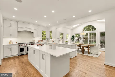 a large kitchen with kitchen island a sink a stove a dining table and chairs