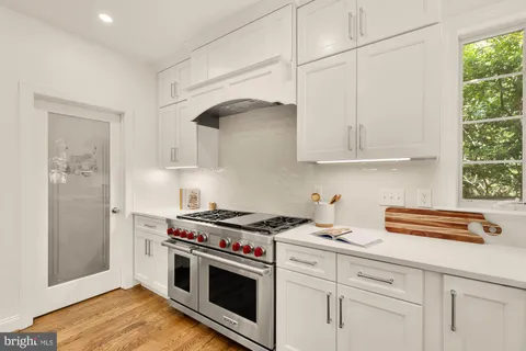 a kitchen with white cabinets and appliances