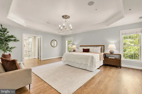 a bedroom with a large bed and a chandelier