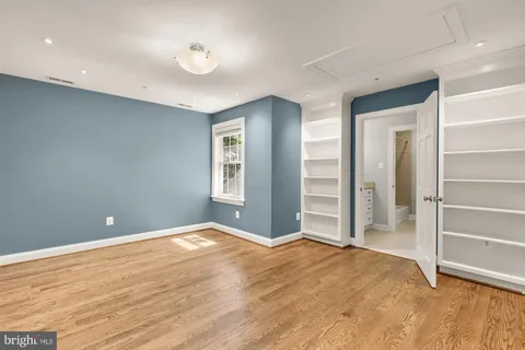 a view of an empty room with closet and a window