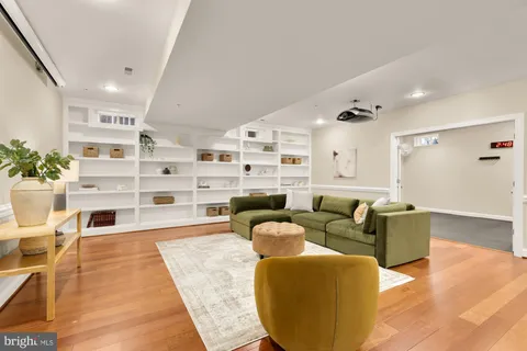 a living room with furniture cabinets and wooden floor