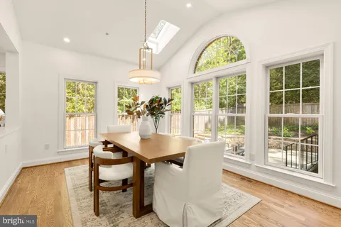 a dining room with furniture a chandelier and wooden floor