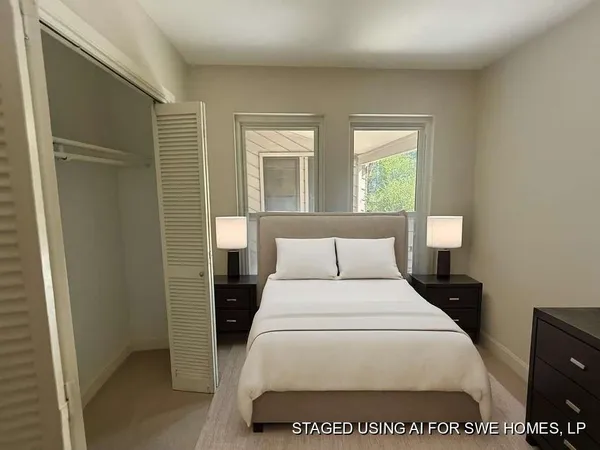 a large white bed in a bedroom next to a window