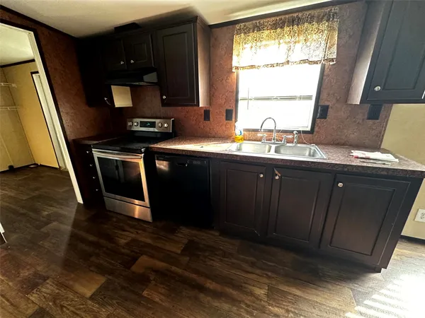 a kitchen with a sink stove and cabinets