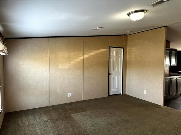 an empty room with wooden floor and entrance