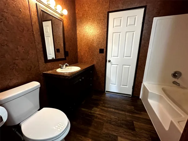 a bathroom with a toilet sink and mirror