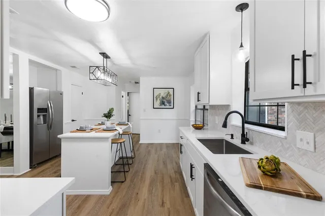 a kitchen with stainless steel appliances a sink stove and refrigerator