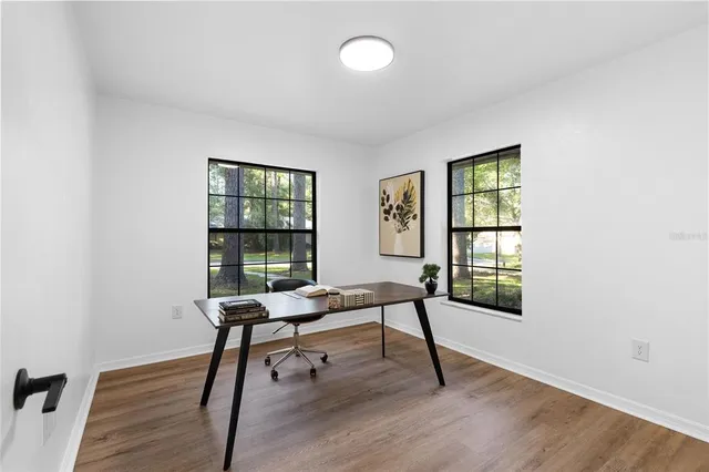 a view of a workspace with furniture and a window