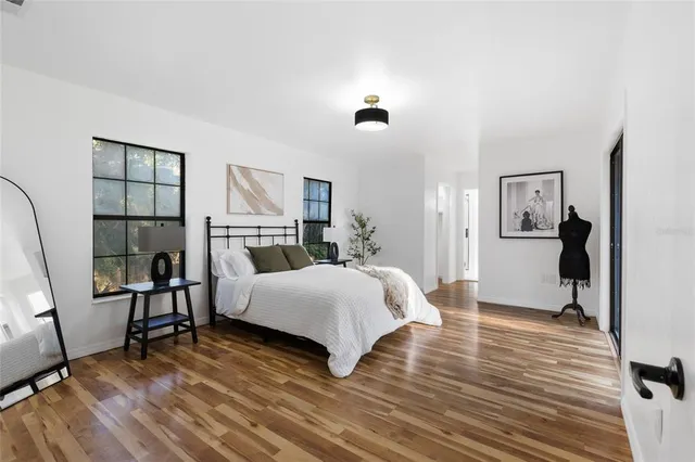 a spacious bedroom with a bed and a flat screen tv