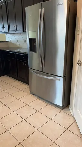 a kitchen with granite countertop a refrigerator and a sink